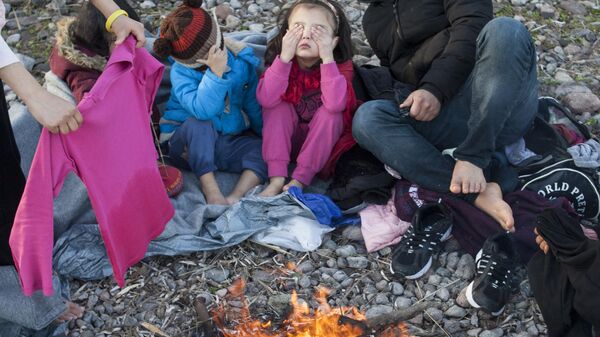 Мигранты у костра в лагере беженцев на острове Лесбос в Греции