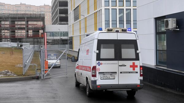 Машина скорой помощи заезжает на территорию больничного комплекса в Коммунарке
