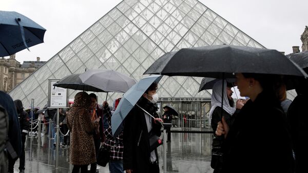 Туристы у здания Лувра, закрытого для посещения в связи с ситуацией с коронавирусом во Франции 