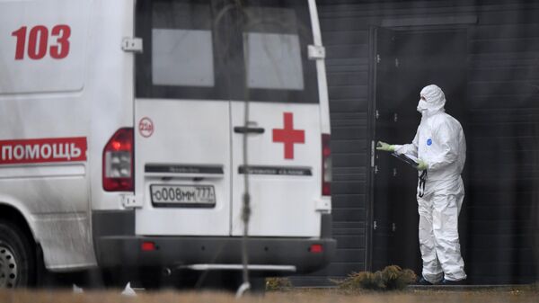 Сотрудник скорой помощи в защитном костюме на территории больничного комплекса в Коммунарке.