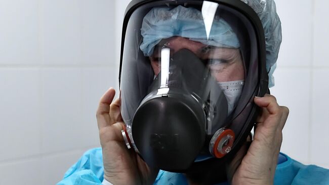 Медик в защитной маске в отдельном режимном корпусе Городской клинической инфекционной больницы имени С. П. Боткина, где размещены люди с подозрением на коронавирусную инфекцию