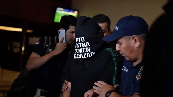 Paraguayan police officers arrest an unidentified man at the Hotel Yacht y Golf Club in Asuncion, Paraguay on March 4, 2020 where two passports with allegedly adulterated contents were seized from the suite where Brazilian footballer Ronaldinho is staying. - Former Brazilian soccer star Ronaldinho and his brother Roberto were wanted by Paraguayan authorities for alleged possession of adulterated passports with which they entered the country, local authorities said Wednesday. (Photo by NORBERTO DUARTE / AFP)
