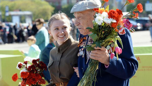 Ветеран Великой Отечественной войны и девушка-волонтер во время празднования Дня Победы