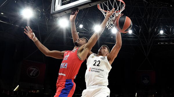 Real Madrid's Cape Verdean centre Walter Tavares (R) challenges CSKA Moscow's US guard Cory Higgins during the EuroLeague semi-final basketball match between CSKA Moscow and Real Madrid at the Fernando Buesa Arena in Vitoria on May 17, 2019. (Photo by LLUIS GENE / AFP)