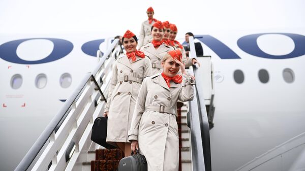 Стюардессы спускаются по трапу дальнемагистрального широкофюзеляжного пассажирского самолета Airbus A350-900 авиакомпании Аэрофлот в международном аэропорту Шереметьево имени А. С. Пушкина в Москве