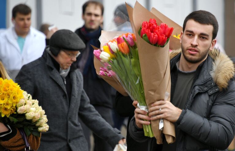 Покупатель с цветами на Рижском рынке в Москве