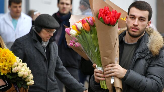 Покупатель с цветами на Рижском рынке в Москве
