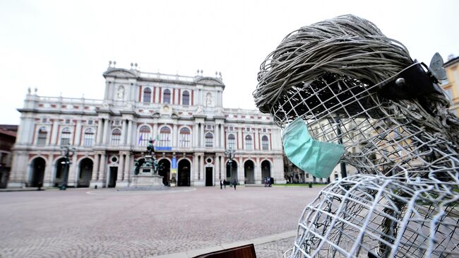Защитная маска на скульптуре в Турине, Италия