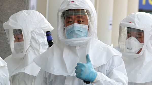 Медицинский работник в защитном костюме обращается к СМИ, перед тем, как зайти в больницу для пациентов с коронавирусом в Тэгу, Южная Корея. 8 марта 2020 