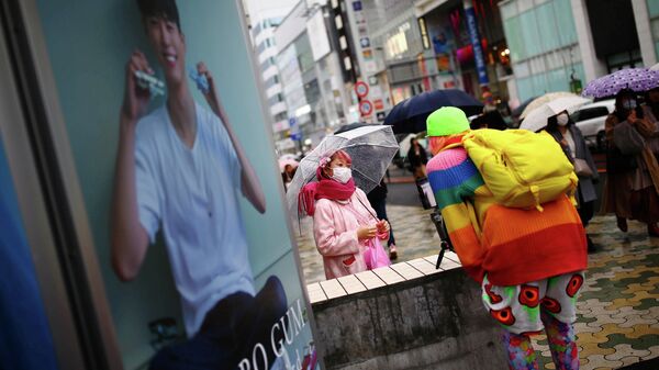 Женщина в защитной маске на улице Токио, Япония.