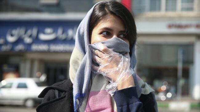 Девушка прикрывает лицо платком на улице Тегерана, Иран