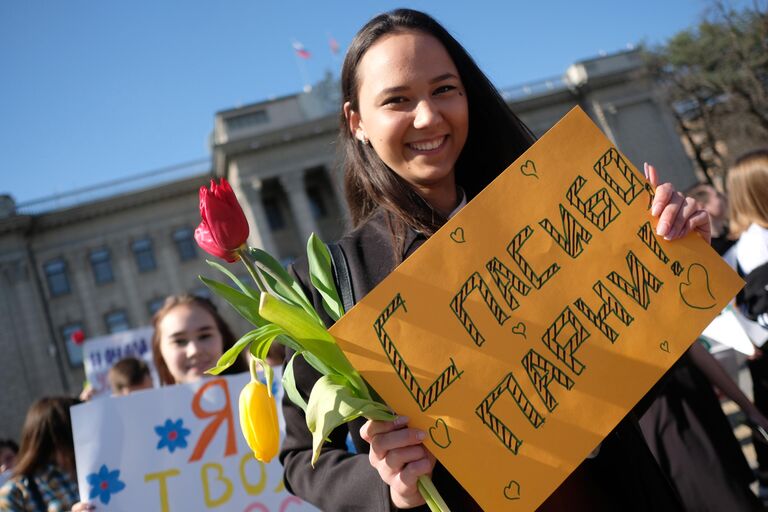 Участники флешмоба Цветы любимым! в рамках празднования Международного женского дня на Пушкинской набережной в Парке Горького в Москве