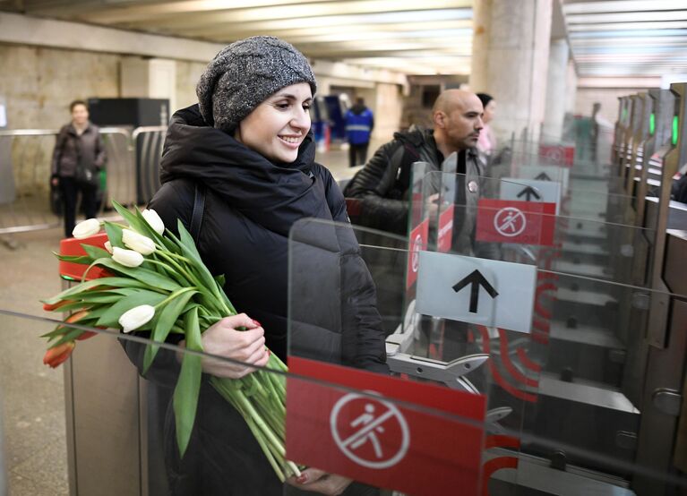 Девушка проходит через турникет в метрополитене