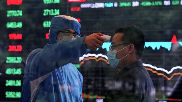 Медработник осуществляет замер температуры у мужчины в здании Шанхайской фондовой биржи