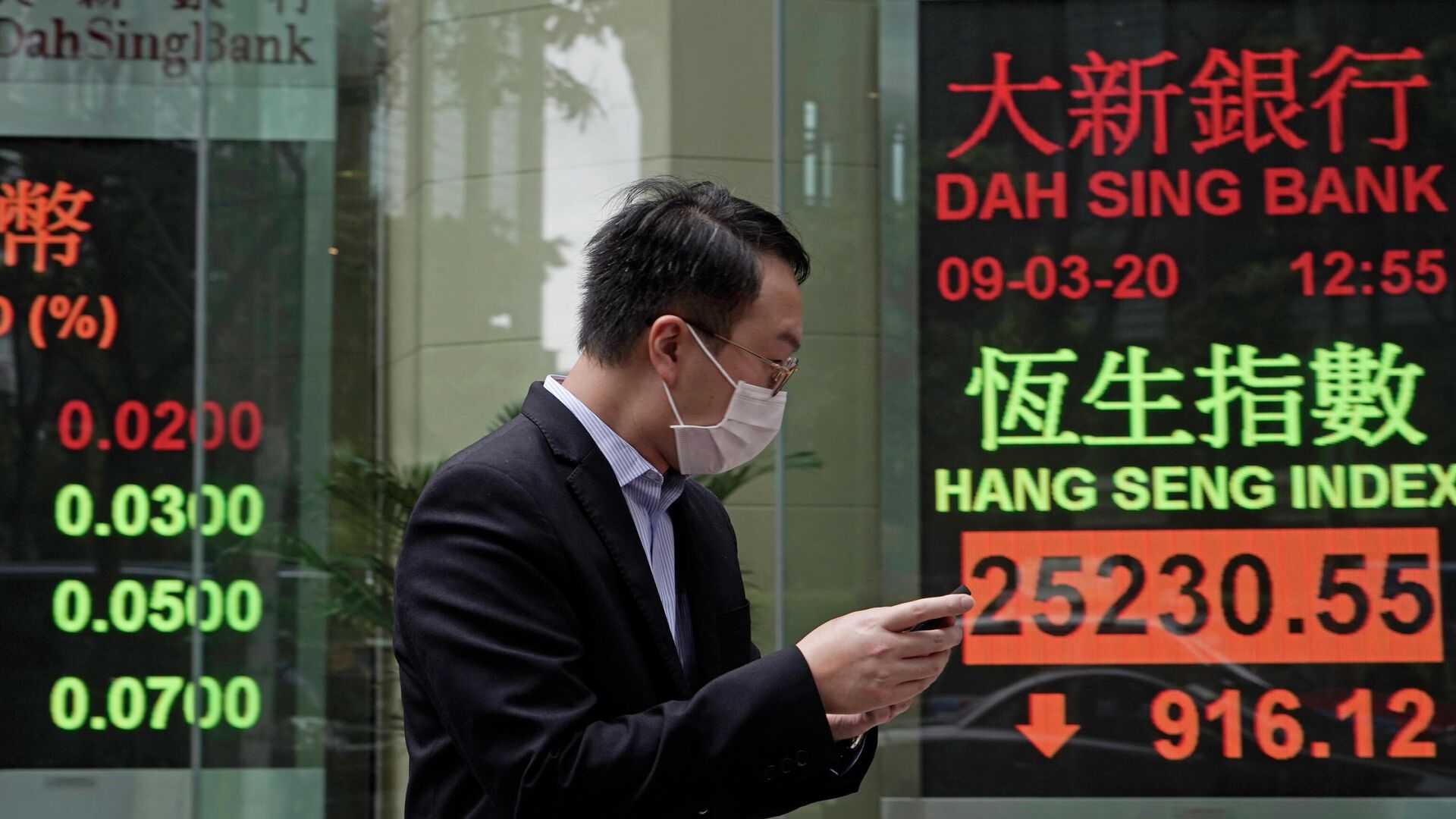 Мужчина в защитной маске на фоне табло с котировками ценных бумаг в Гонконге  - РИА Новости, 1920, 17.09.2020