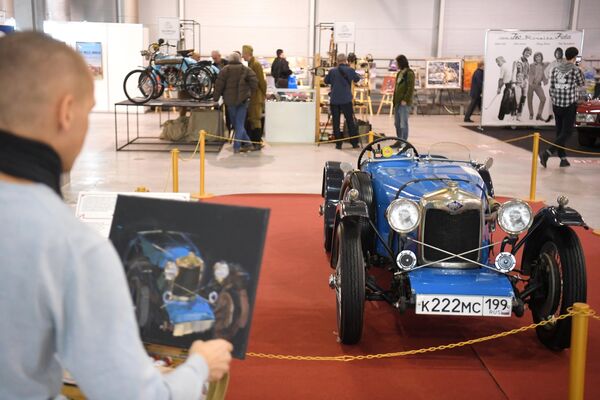 Мужчина рисует британский гоночный автомобиль Riley Brooklands Nine (1930) на открытии 29-й выставки старинных автомобилей и антиквариата Олдтаймер-Галерея 2020