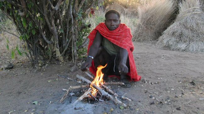 Мужчина племени хадза (Танзания), сидящий на корточках
