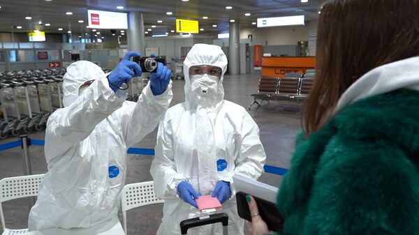Медицинские работники проводят осмотр пассажиров в аэропорту Шереметьево