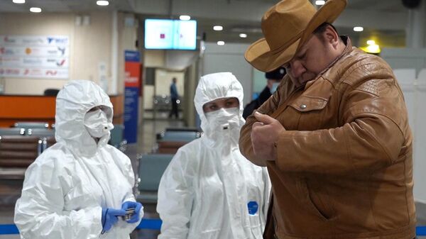 Медицинские работники проводят осмотр пассажира в аэропорту Шереметьево