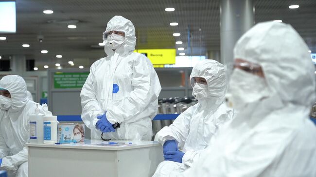 Медицинские работники перед началом осмотра пассажиров в аэропорту 
