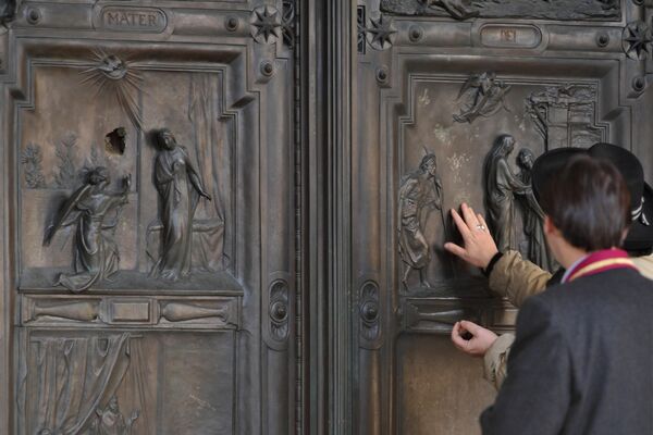 Люди у входной двери Базилики Санта-Мария-Маджоре в Риме, которую пробил камнем вандал