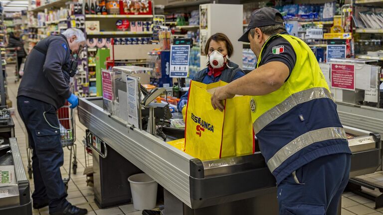 Сотрудники социальной службы покупают продукты людям пожилого возраста для предотвращения распространения инфекции