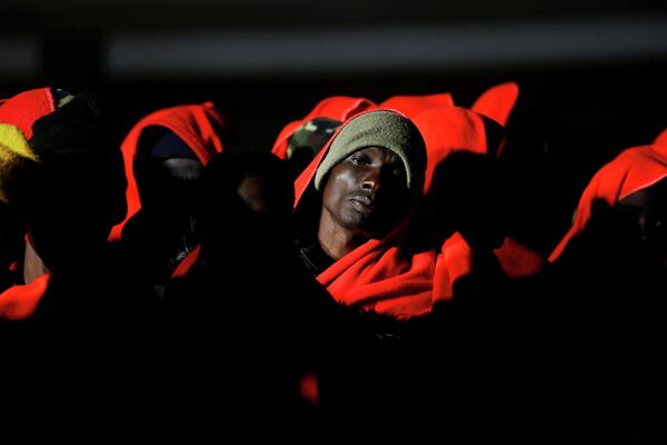 Мигранты ожидают высадки со спасательного катера в порту Малага, на юге Испании