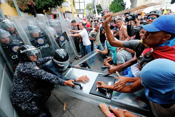 Оппозиционные протестующие во время столкновений с полицией в Каракасе