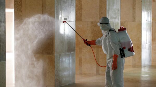 Персонал Индонезийского Красного Креста распыляет дезинфицирующее средство в рамках борьбы с эпидемией коронавируса  в мечети Истикляль. 13 марта 2020