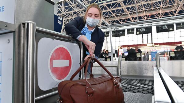 Сотрудница авиакомпании производит регистрацию пассажиров и багажа на рейс в Международном аэропорту Сочи