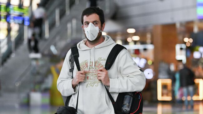 Пассажир в медицинской маске в аэропорту Сочи