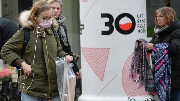 Женщина в медицинской маске на улице в Варшаве