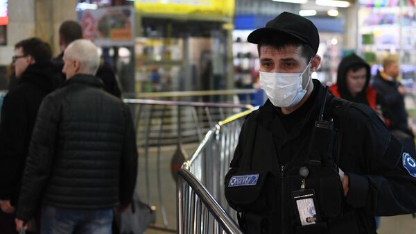 Сотрудник вневедомственной охраны в медицинской маске на входе в Московский метрополитен