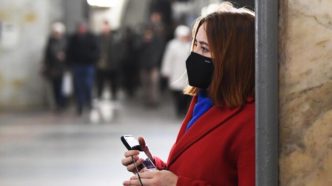 Девушка в защитной маске в Московском метрополитене