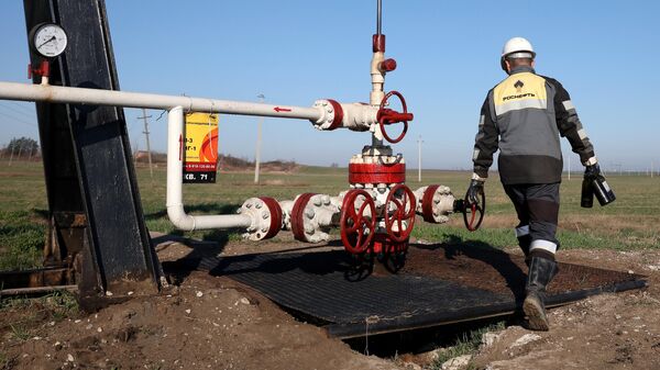 Сотрудник Роснефти осматривает оборудование на нефтегазовом месторождении