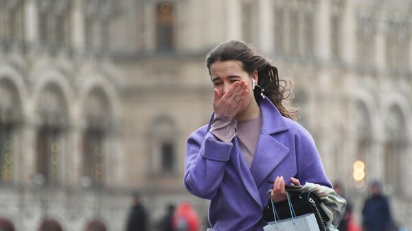 Девушка идет по Красной площади под порывами ветра