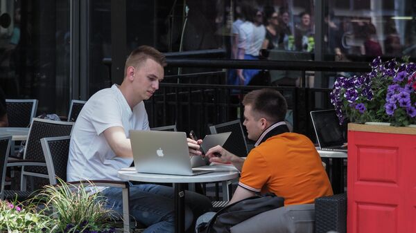 Мужчины с ноутбуками на веранде кафе