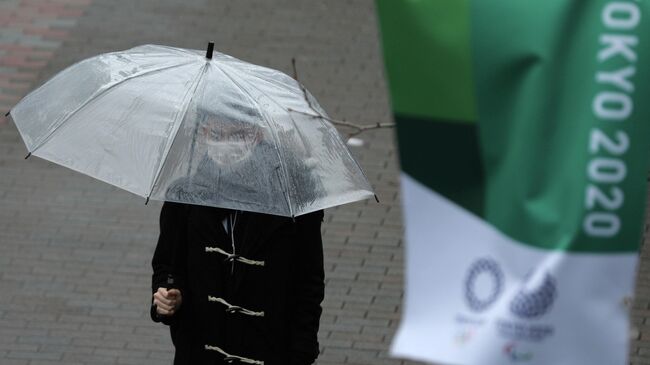 A man, wearing a protective face mask, following an outbreak of the coronavirus disease (COVID-19), walks next to a banner for Tokyo 2020 Olympic games in Tokyo, Japan March 8, 2020. REUTERS/Stoyan Nenov