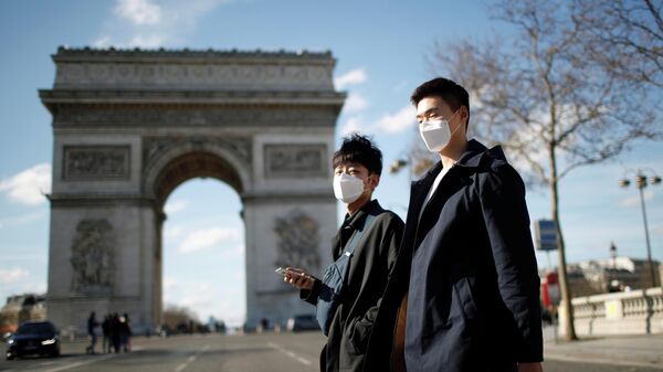Люди в защитных масках у Триумфальной арки в Париже