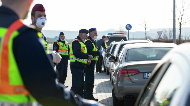 Венгерские полицейские проверяют документы у водителей, прибывших из Словении, в связи с усиленным контролем из-за эпидемии коронавируса 