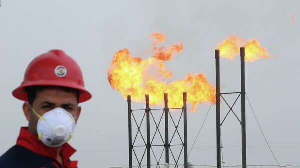 Рабочий в защитной маске на нефтяном месторождении в Ираке