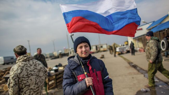 Мальчик с российским флагом на блокпосту на перешейке в районе Чонгара