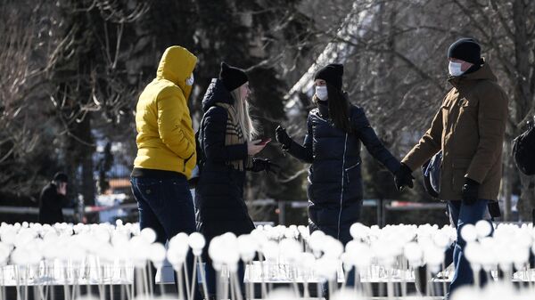 Молодые люди в медицинских масках гуляют на ВДНХ в Москве
