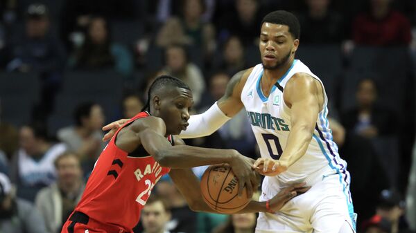 Баскетболист Торонто Рэпторс Крис Буше против Майла Бриджеса из Шарлотт Хорнетс в матче НБА