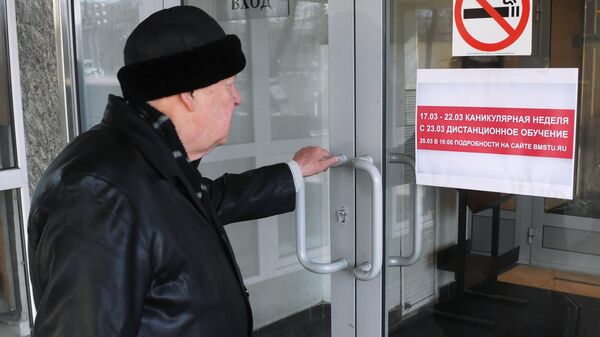 Мужчина на входе в здание Московского Государственного Технического Университета имени Н. Э. Баумана в Москве