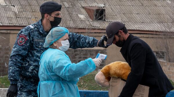 Медицинский работник проверяет температуру у прохожего в армянском Вагаршапате
