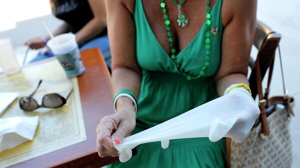 Девушка надевает латексную перчатку в баре во Флориде