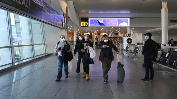 Пассажиры в медицинских масках в аэропорту Брюсселя