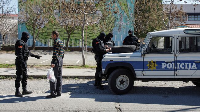 Полицейские проверяют мужчину в Подгорице в связи с мерами по борьбе с распространением коронавируса