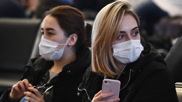 Пассажиры в медицинских масках в зале ожидания железнодорожного вокзала Новосибирский Главный в Новосибирске